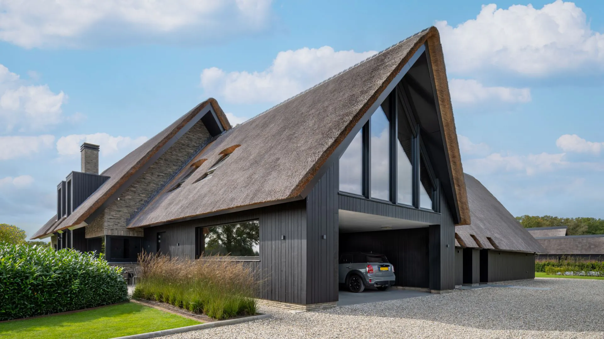 Moderne rietgedekte woning met lichte gevelstenen.
